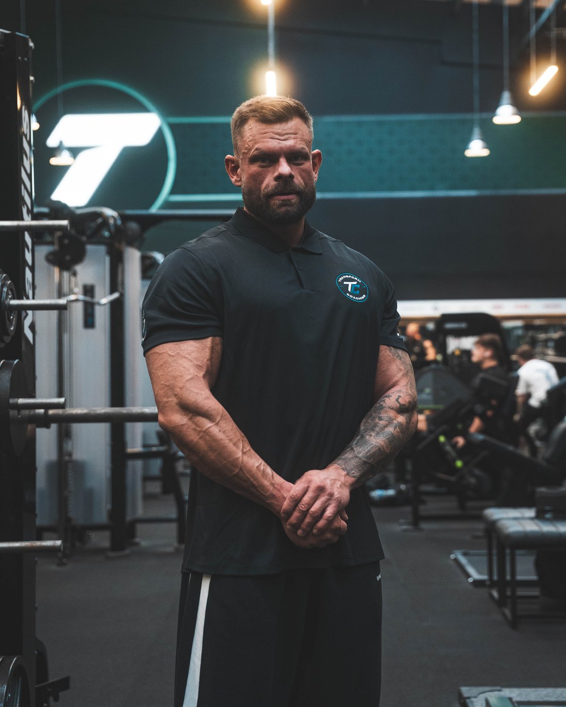 Jack Wall in a Transform Coaching polo on the gym floor